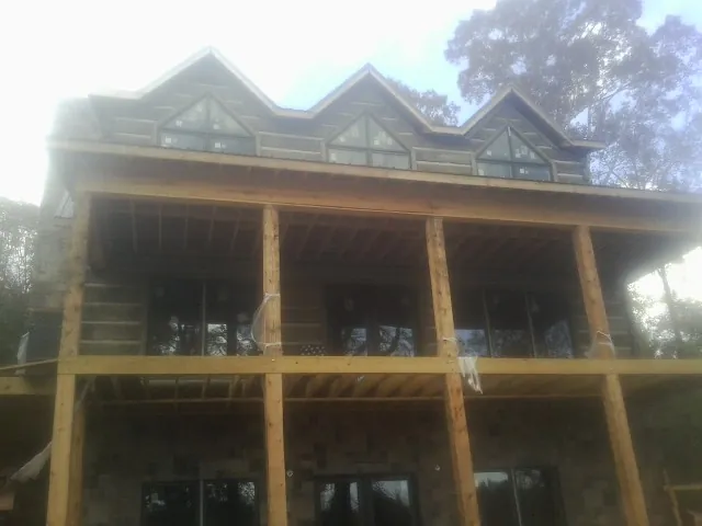 Dormers and porch framing on a large log home under construction — Roof Coating work by our crew in Whitehouse